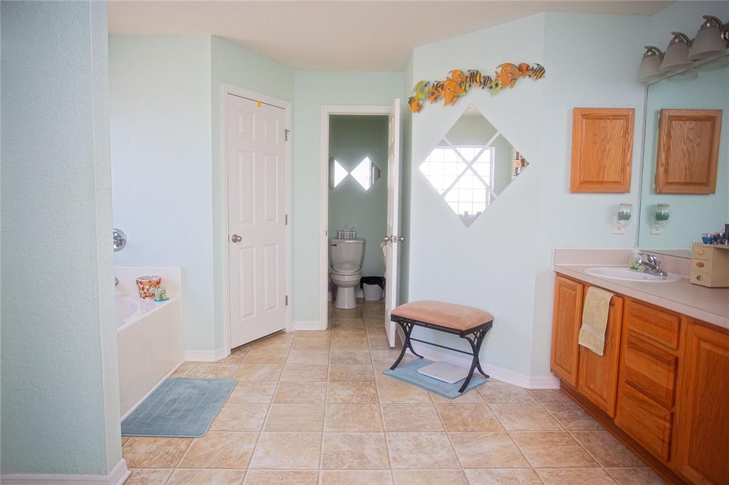 9086 Manchester Street Spring Hill, FL 34606 - Photo 28 of 50 a living room with furniture and a mirror
