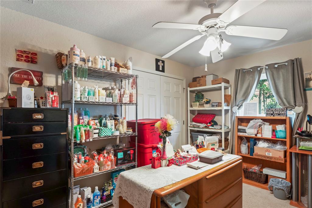 9086 Manchester Street Spring Hill, FL 34606 - Photo 32 of 50 a room with furniture a chandelier and a book shelf