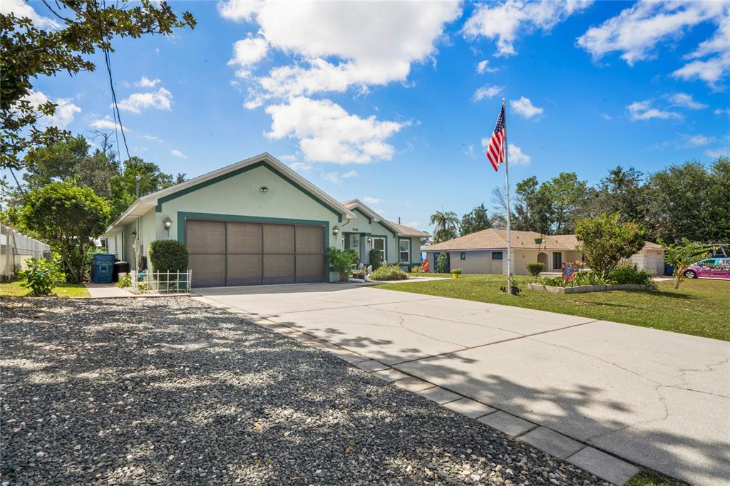 9086 Manchester Street Spring Hill, FL 34606 - Photo 42 of 50 a front view of a house with a yard and garage