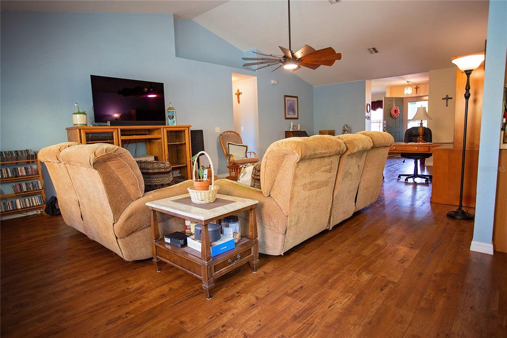 9086 Manchester Street Spring Hill, FL 34606 - Photo 5 of 50 a living room with furniture and a flat screen tv