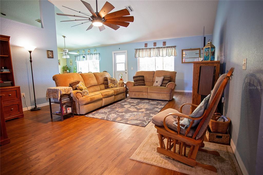 9086 Manchester Street Spring Hill, FL 34606 - Photo 6 of 50 a living room with furniture a fireplace and a flat screen tv
