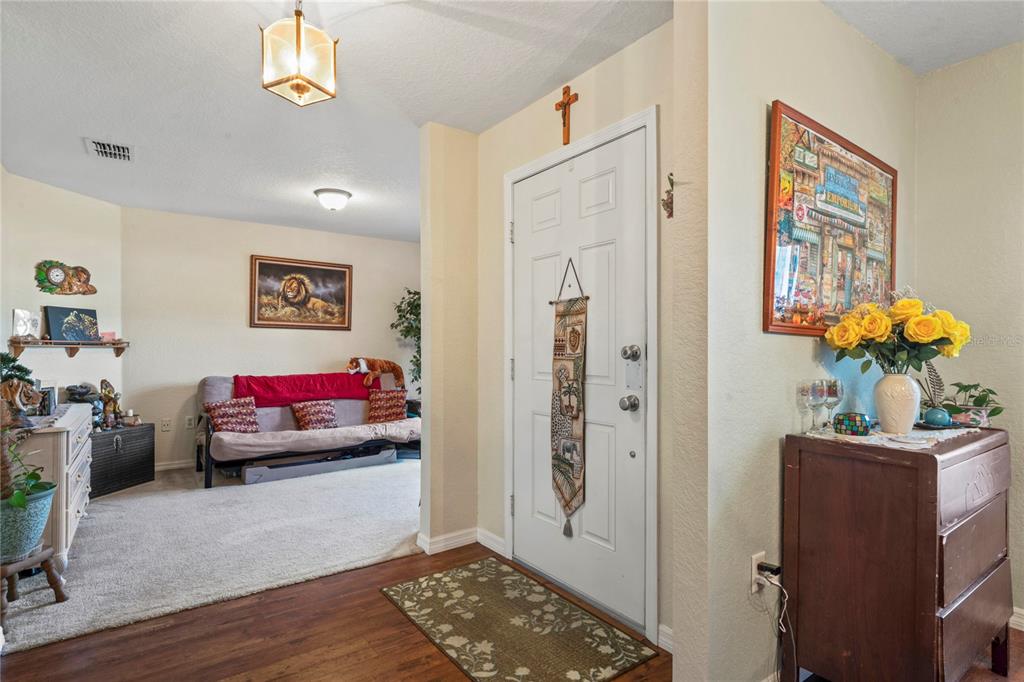 9086 Manchester Street Spring Hill, FL 34606 - Photo 8 of 50 a living room with furniture and a potted plant