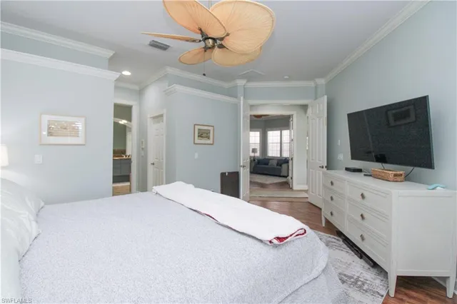 a bedroom with a bed and a flat tv screen on dresser