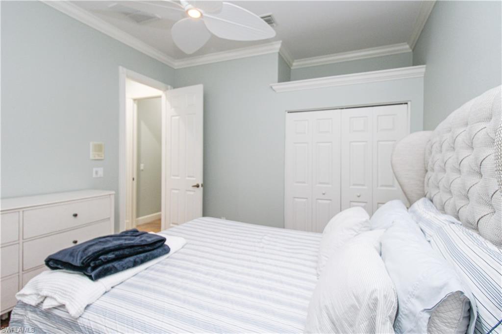 372 Mallory Court Naples, FL 34110 - Photo 30 of 48 a bedroom with a bed a window and dresser