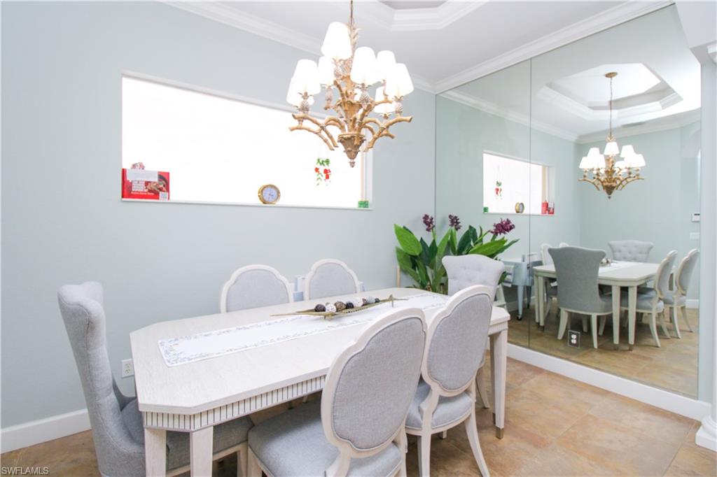 372 Mallory Court Naples, FL 34110 - Photo 8 of 48 a dining room with furniture a chandelier and window