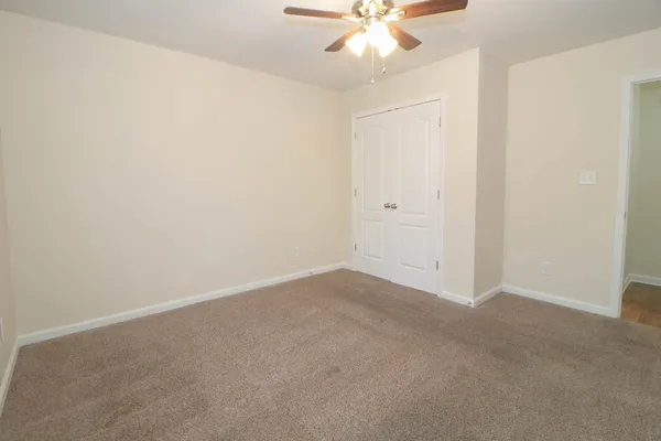an empty room with a chandelier fan