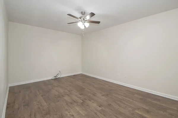 a view of an empty room with chandelier fan