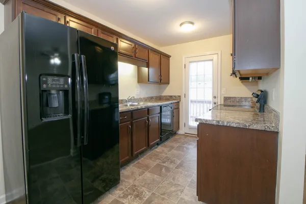 a kitchen with stainless steel appliances granite countertop a refrigerator a sink and a stove