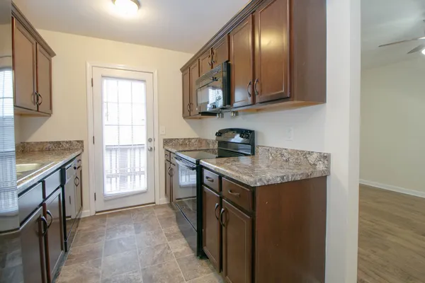 a kitchen with stainless steel appliances granite countertop a stove a sink and a microwave
