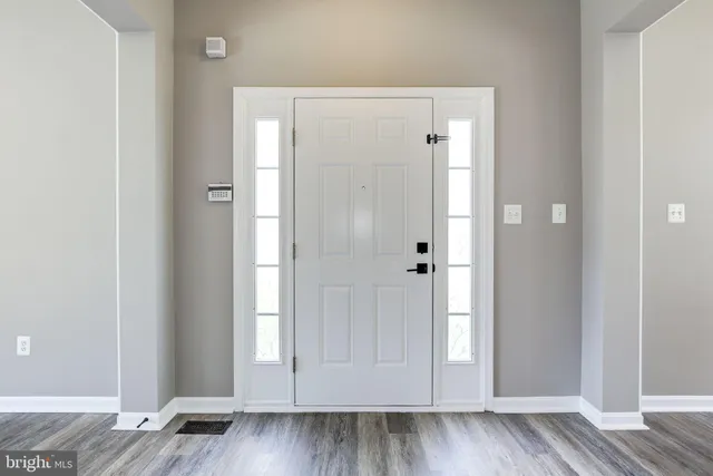 an empty room with wooden floor and entrance