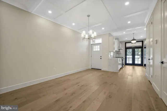 a kitchen with granite countertop a stove a sink dishwasher and white cabinets with wooden floor