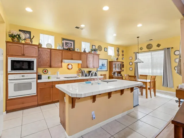 a kitchen with a stove a refrigerator and a dining table