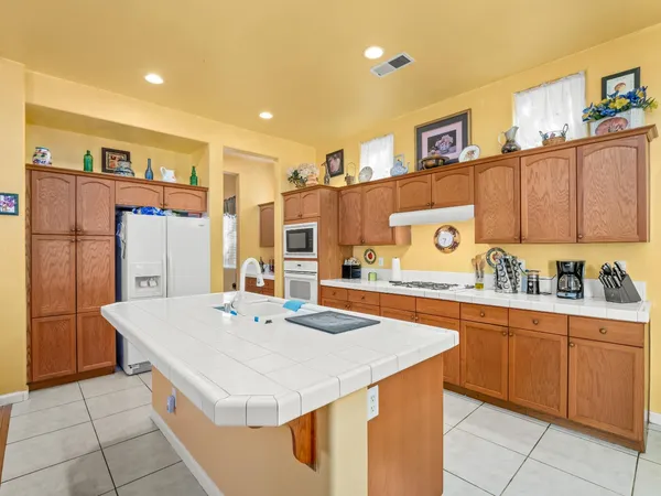 a large kitchen with kitchen island a sink stove and refrigerator