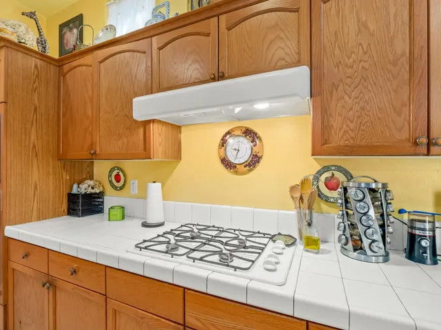 a view of kitchen cabinetry and a stove top oven
