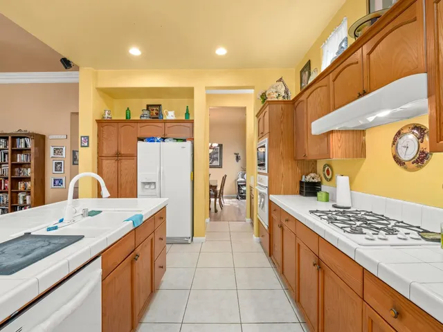 a large kitchen with stainless steel appliances kitchen island granite countertop a sink and cabinets