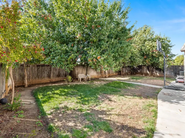 a backyard of a house with table and chairs