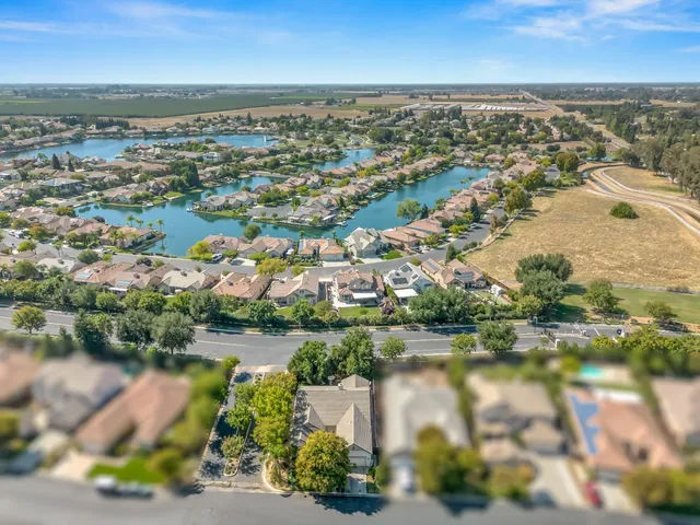 an aerial view of residential houses with outdoor space and lake view