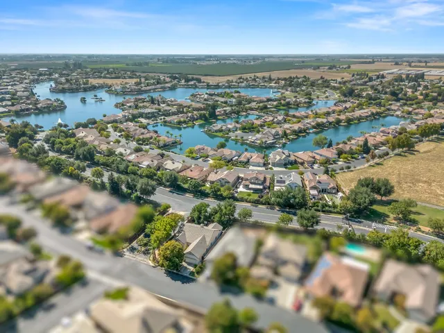 an aerial view of residential houses with outdoor space and lake view