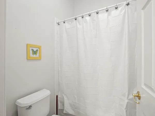 a white toilet sitting next to a shower curtain