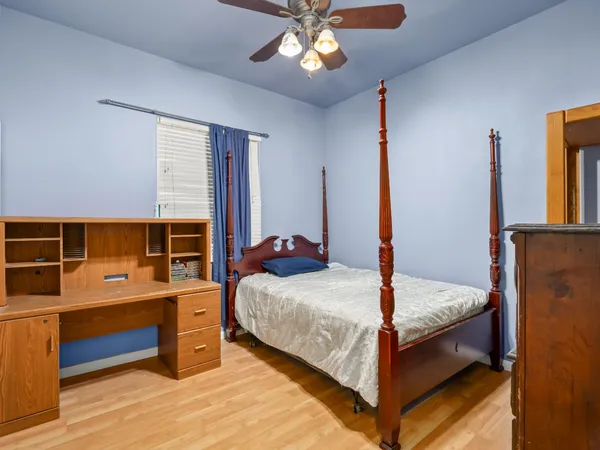 a bed room with a bed and a ceiling fan