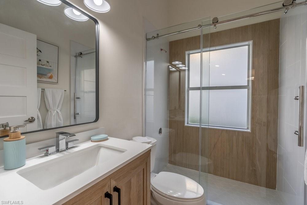 6831 Mill Pond Circle Naples, FL 34109 - Photo 14 of 45 a bathroom with a sink toilet a mirror and shower