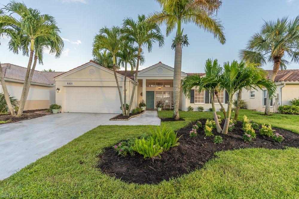 6831 Mill Pond Circle Naples, FL 34109 - Photo 20 of 45 a front view of house with small garden and palm trees