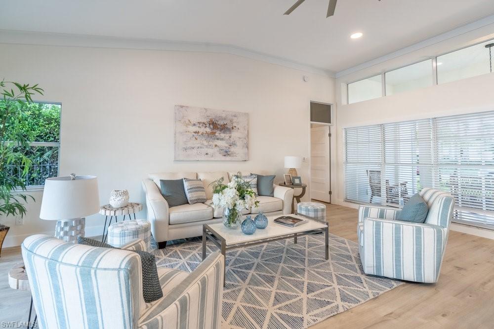 6831 Mill Pond Circle Naples, FL 34109 - Photo 2 of 45 a living room with furniture a lamp and a potted plant