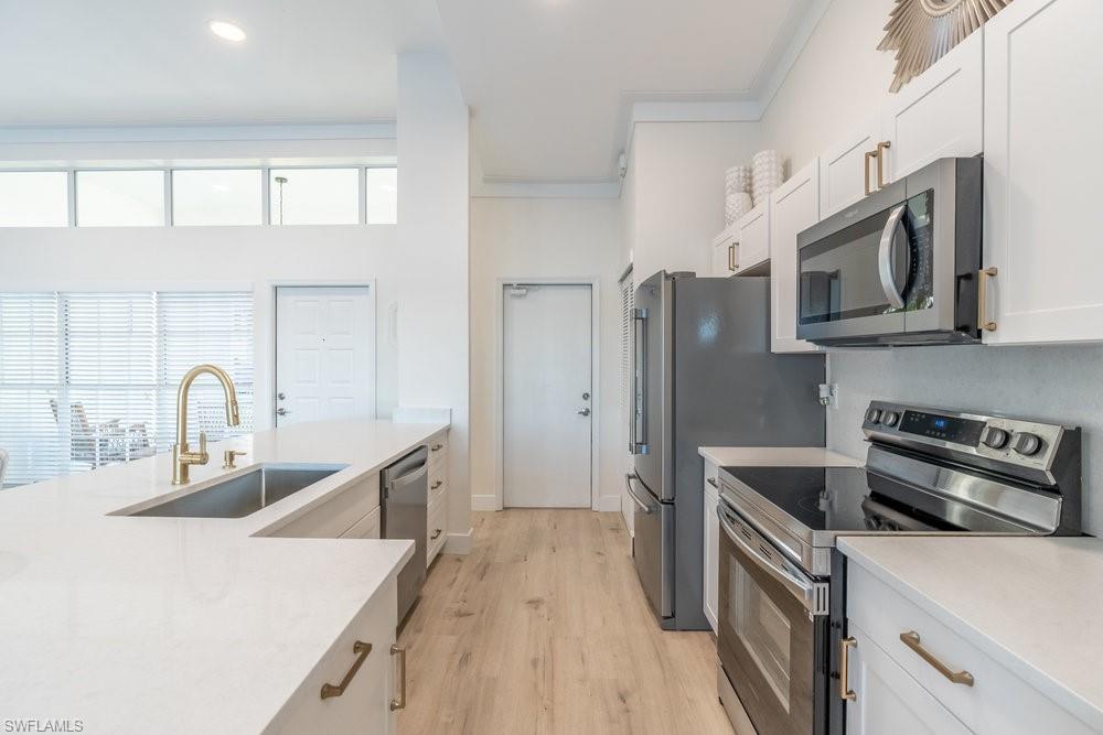 6831 Mill Pond Circle Naples, FL 34109 - Photo 7 of 45 a kitchen with stainless steel appliances granite countertop a sink stove and refrigerator