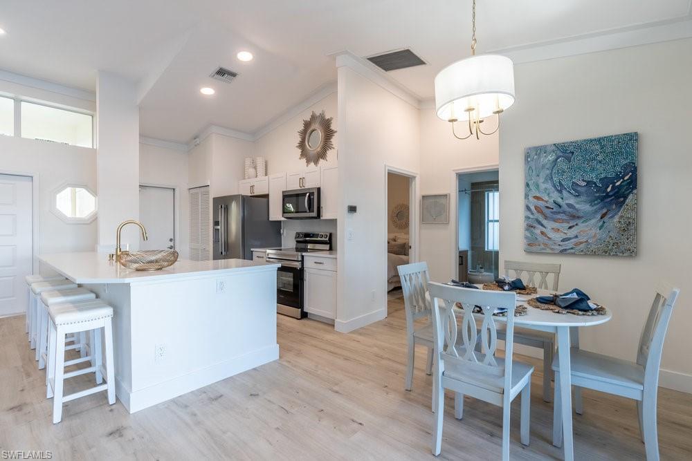 6831 Mill Pond Circle Naples, FL 34109 - Photo 8 of 45 a view of kitchen with cabinets and wooden floor