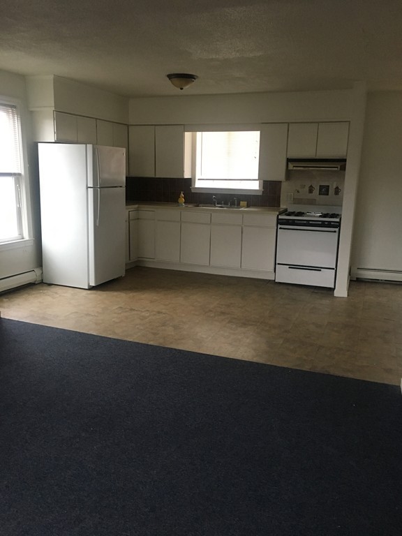 128 Stewart Street Fall River, MA 02720 - Photo 12 of 14 a kitchen with granite countertop a sink and a refrigerator