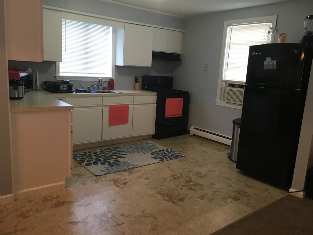 128 Stewart Street Fall River, MA 02720 - Photo 6 of 14 a kitchen with a refrigerator and a stove top oven
