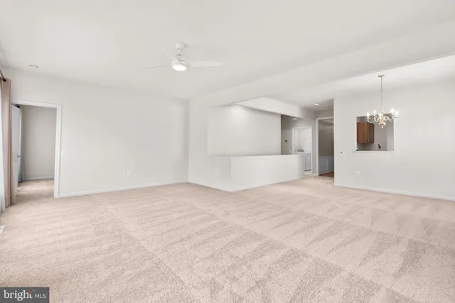 a view of a big room with a chandelier fan and refrigerator