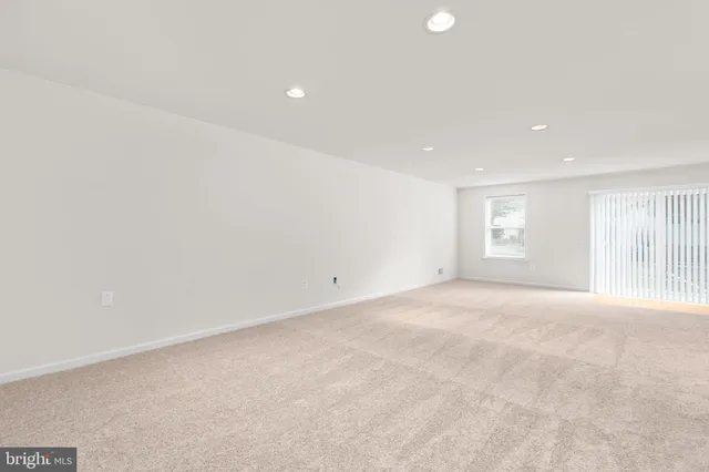 an empty room with a ceiling fan and window