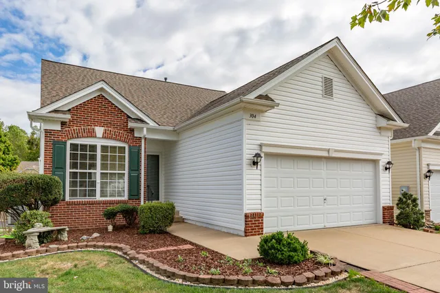 a view of a hallway with wooden floor and a bathroom