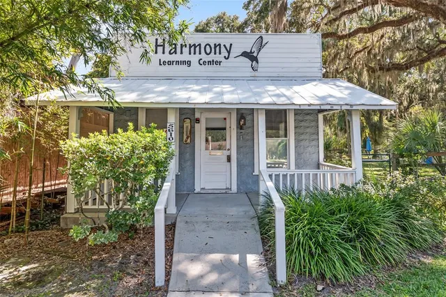 a view of a house with potted plants and a table and chairs