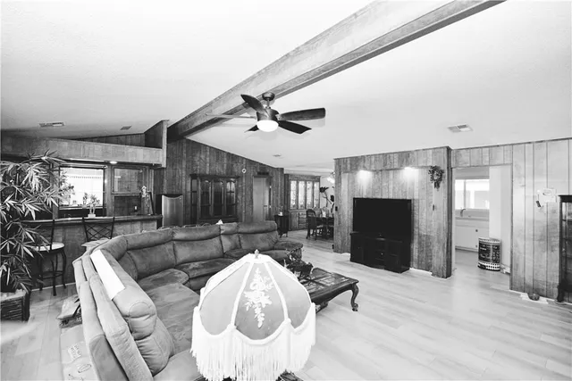 a living room with furniture a flat screen tv and a large window