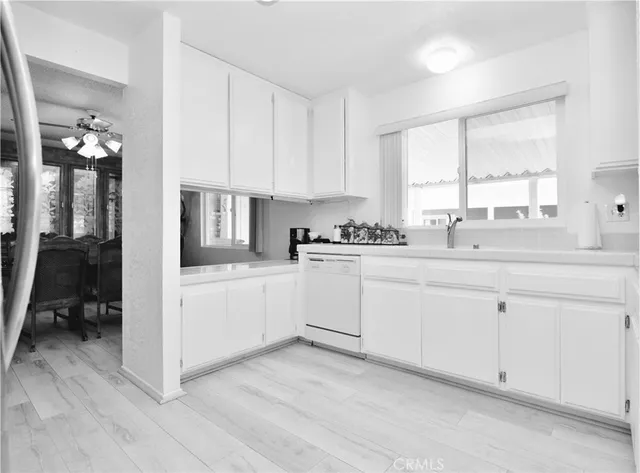 a kitchen with white cabinets white appliances and sink