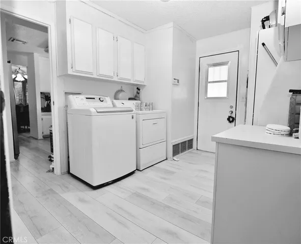 a utility room with cabinets washer and dryer