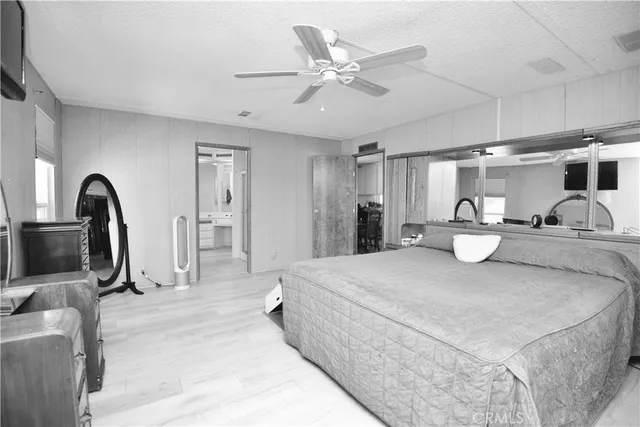 a bedroom with a bed a mirror and gym equipment