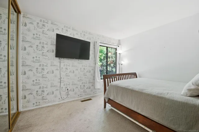 a bedroom with a bed and a flat screen tv