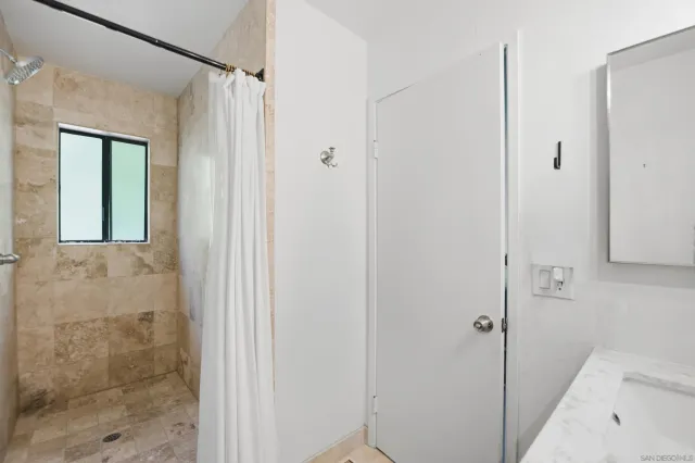 a bathroom with a shower and a sink