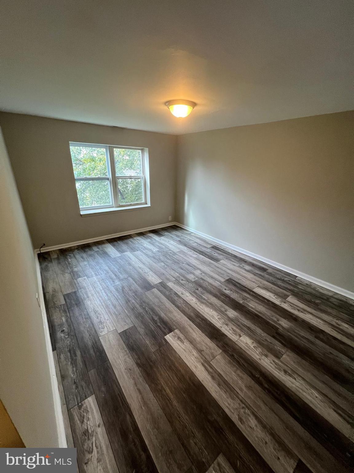 1025 Elton Avenue Baltimore, MD 21224 - Photo 7 of 11 a view of an empty room with wooden floor and a window