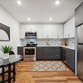 a kitchen with stainless steel appliances a stove a sink a microwave a refrigerator and cabinets