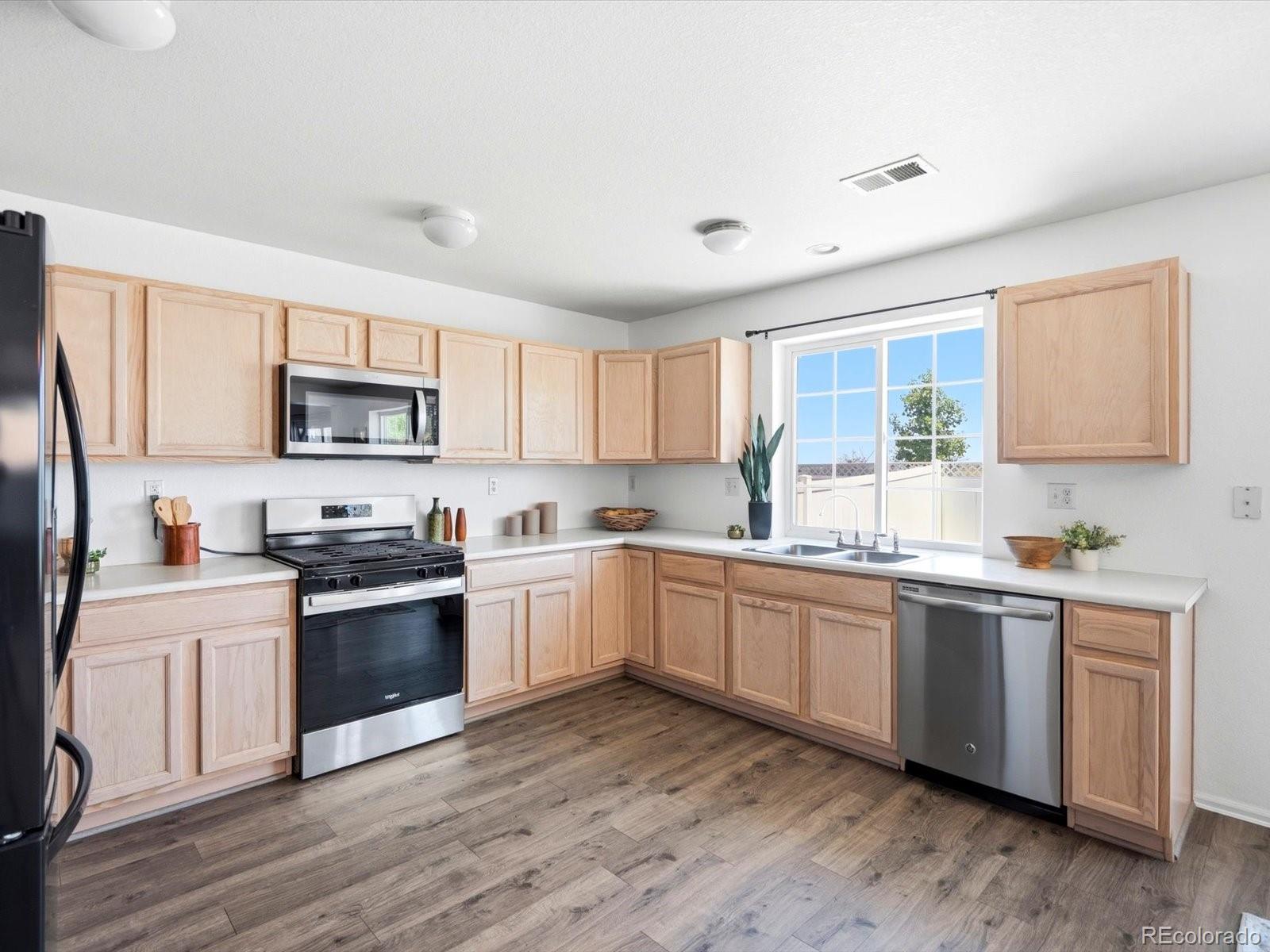 5444 Perth Court Denver, CO 80249 - Photo 8 of 46 a kitchen with sink a microwave and cabinets
