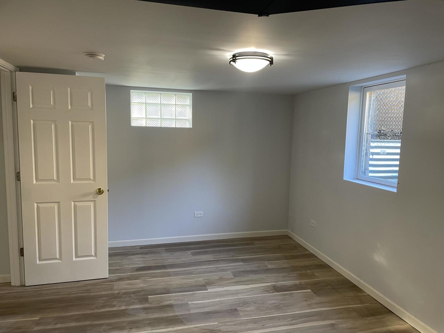 18452 Oakwood Avenue Lansing, IL 60438 - Photo 19 of 21 a view of an empty room with wooden floor and a window