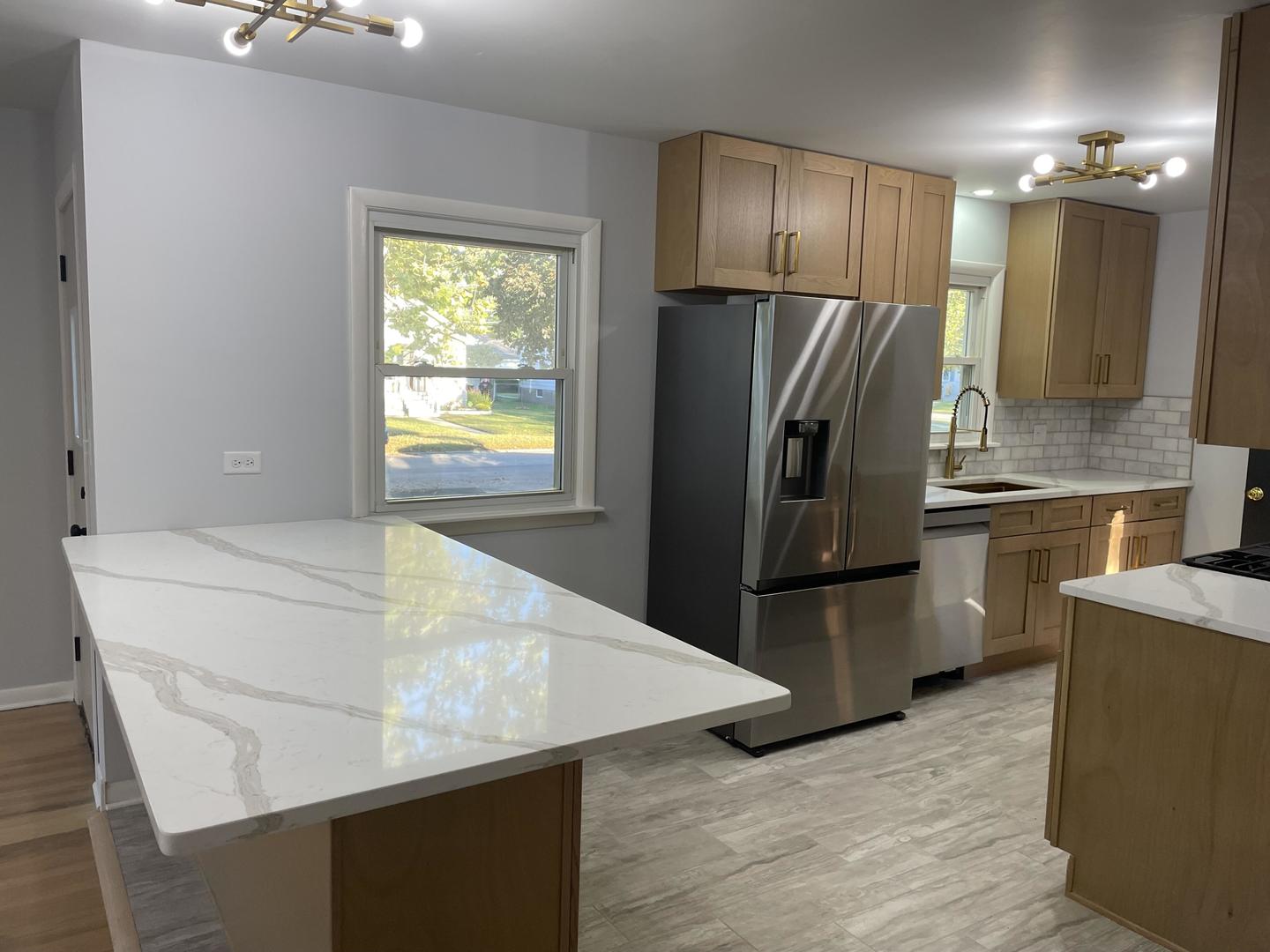 18452 Oakwood Avenue Lansing, IL 60438 - Photo 3 of 21 a kitchen with kitchen island a counter top space cabinets and stainless steel appliances