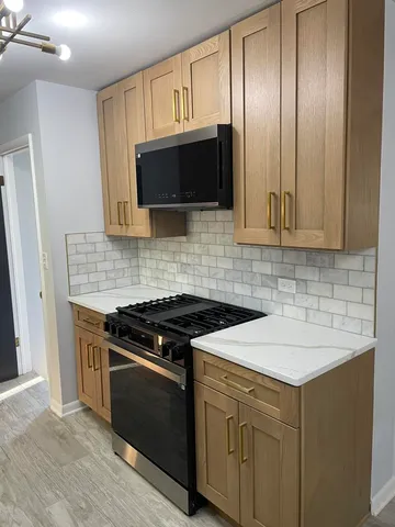 a kitchen with cabinets stainless steel appliances and wooden floor