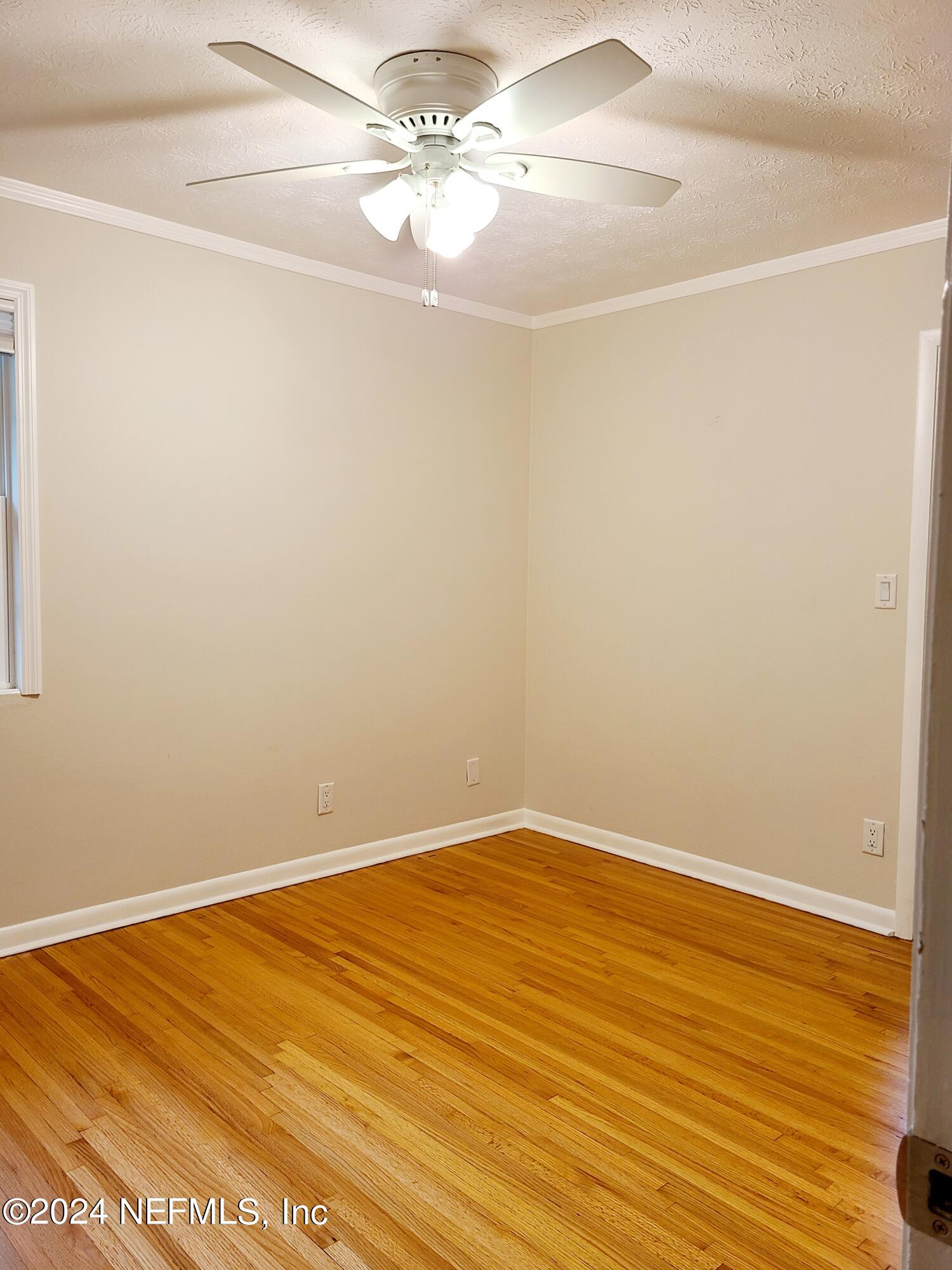 4620 Morris Road Jacksonville, FL 32225 - Photo 18 of 39 an empty room with wooden floor and fan