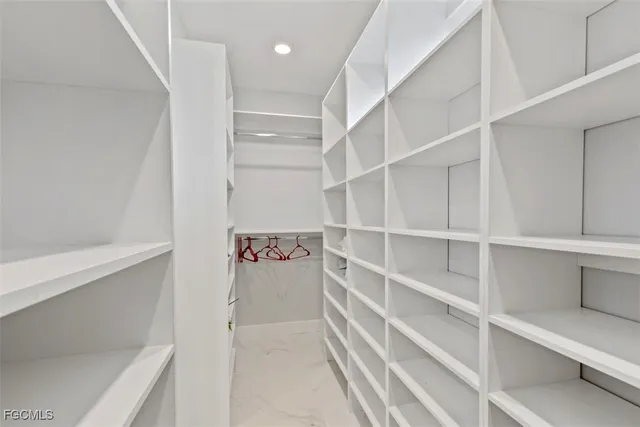 a view of walk in closet with empty racks