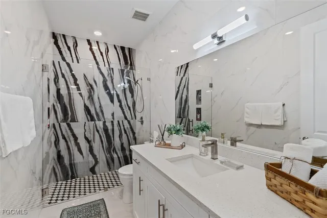 a bathroom with double vanity sink a mirror and a shower